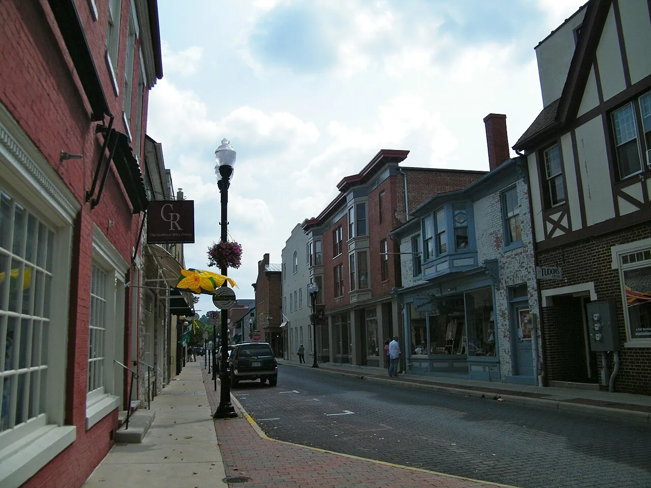 A downtown street in Winchester, Virginia, with brick storefronts and hanging flower baskets